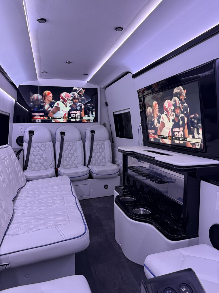 Game day inside the Sprinter with captain's chairs, bench seating and big screens